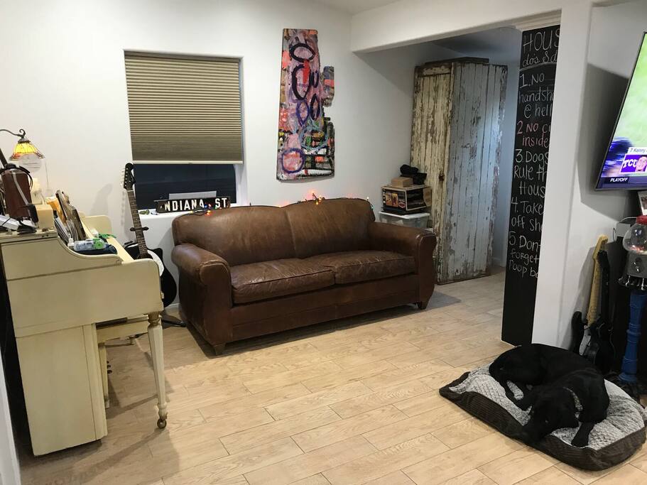 Other side of living room with piano and nice resto hardware leather couch