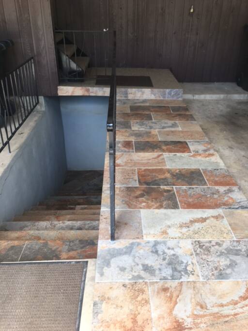 Entrance is down the steps on the left, inside the large carport,