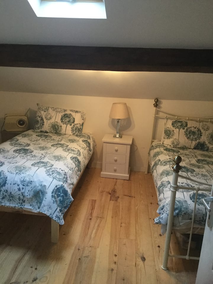 Habitación de buen tamaño con dos camas individuales, armario y cajonera para almacenamiento adicional. Situado en la planta superior junto al baño con ducha. Ventana Velux, muy luminosa y aireada.