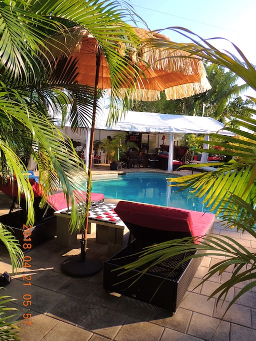 View from lounge chairs to outside living room, dining room, kitchen and bar set under 1000 sq ft gazebo