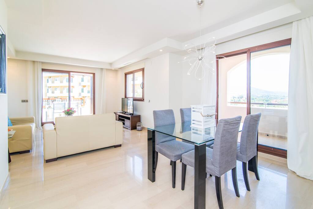 Inside dining area in living room, next to the sofas and full of light