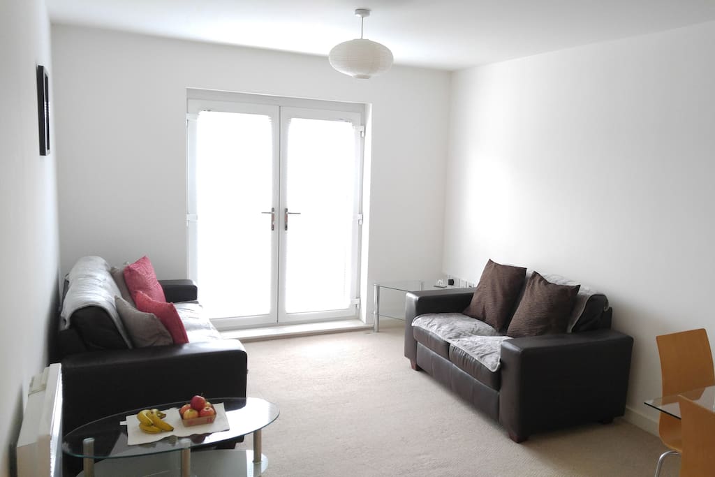 Living area with sofas, coffee table and French Doors to a Juliet Balcony.