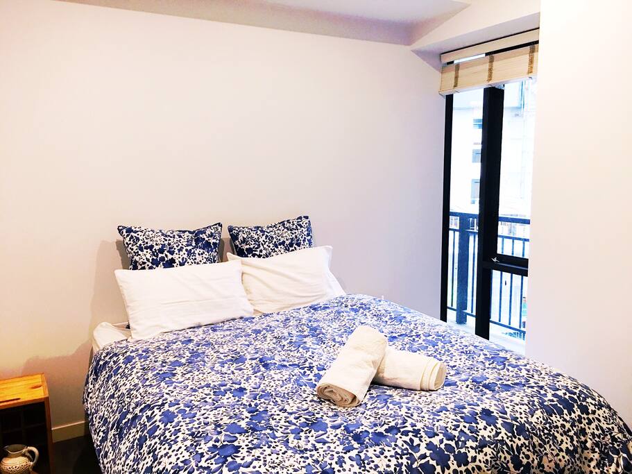 Spacious bedroom with queen bed and view of the city.