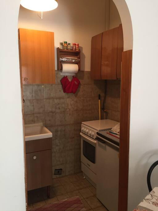 Angolo cottura con fornello e frigorifero.