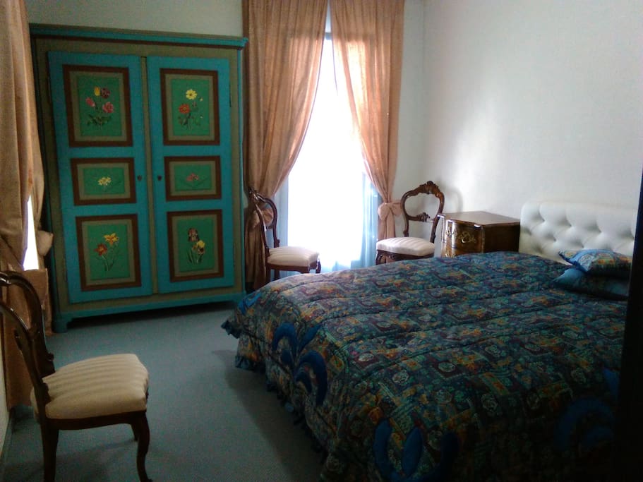Finely furnished private double room with a king bed, bedside tables, beautiful art- wardrobe and chairs