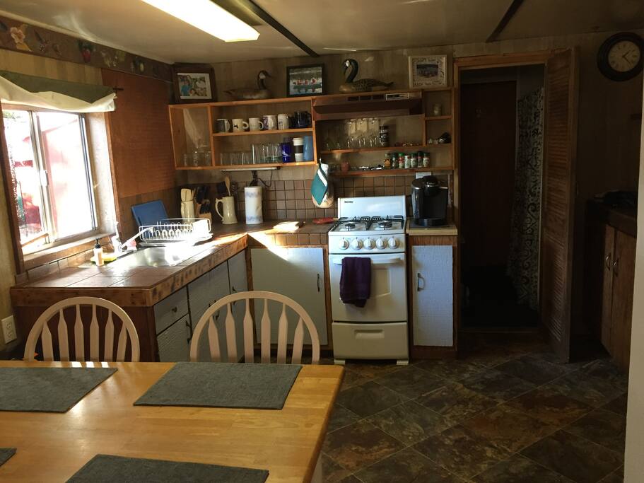 Well stocked Kitchen. Doorway into bathroom & shower