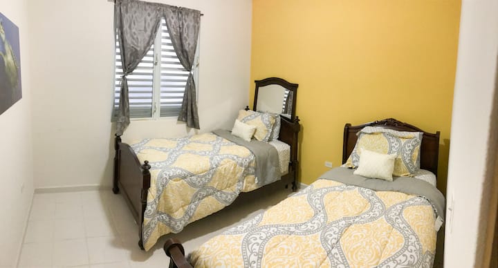 黄色卧室配有两张单人床和一个壁橱。