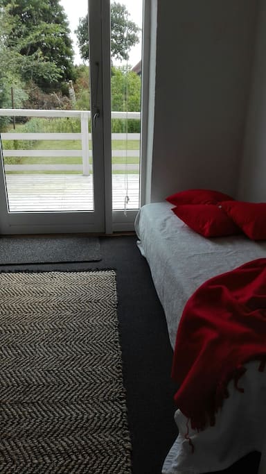 soveværelse med 1 gæsteseng med udgang til terrasse og have