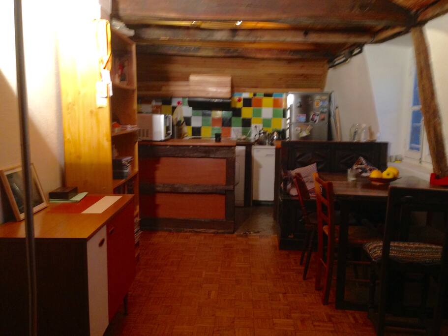 Kitchen and part of living room with table and furniture