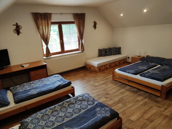 Ložnice v patře s jednou dvoulůžkovou postelí a čtyrmi single postelemi