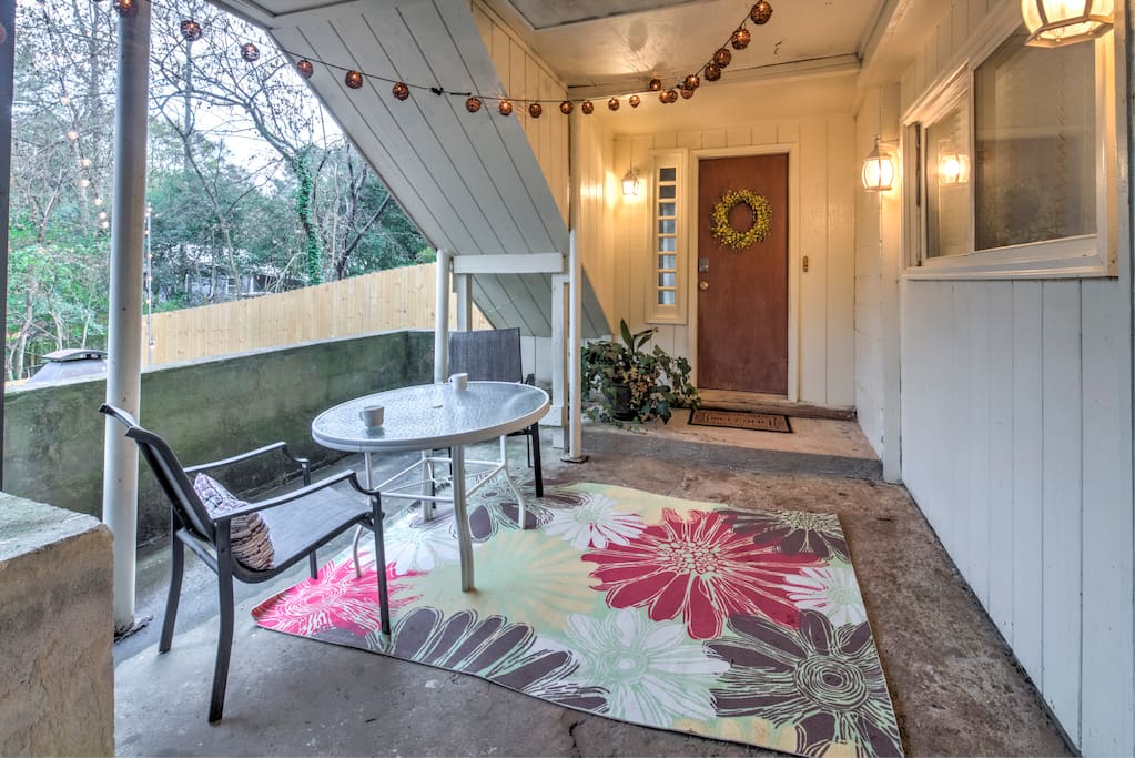 Private entrance into the apartment with outdoor seating space under warm string lights