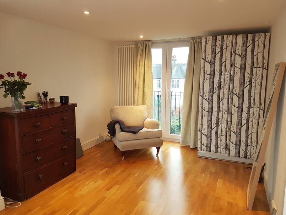 Extra large bedroom with tons of light and sumptuous armchair for reading