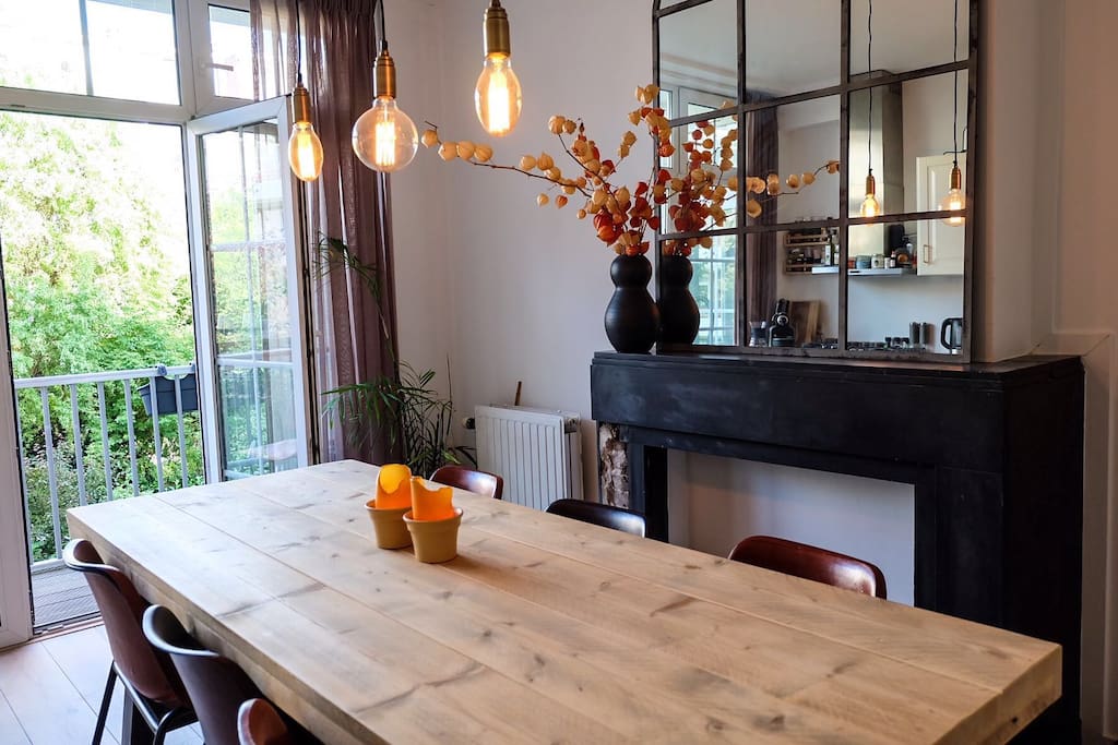 Beautiful kitchen area with a large table for a great dinner, with the doors to the balcony wide open. The old fireplace gives the room a great atmosphere.