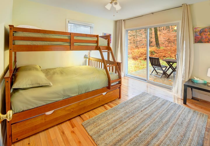 Third bedroom with a twin over full bunk bed, opens to back deck, with large blackout curtains.