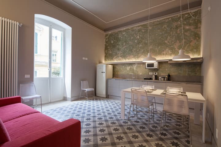 Sala de estar con cocina pequeña y sofá cama