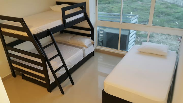 Habitación # 2.Espaciosa habitación para 4 o 5 personas. Cuatro camas sencillas y una semidoble. Baño privado.