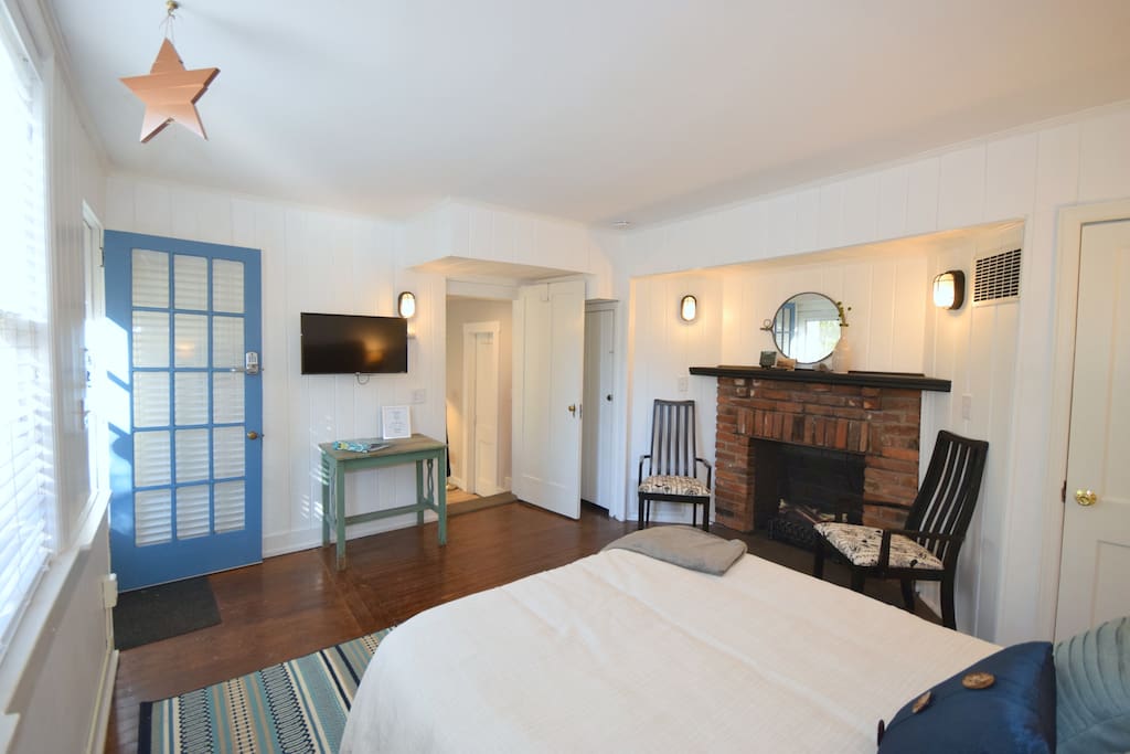 X-L bedroom, this view shows entry door, TV, fireplace with electric logs + heater, Queen size bed.