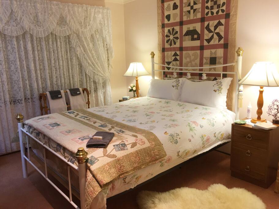 Beautiful, peaceful room with a Queen bed on a brass bed frame.