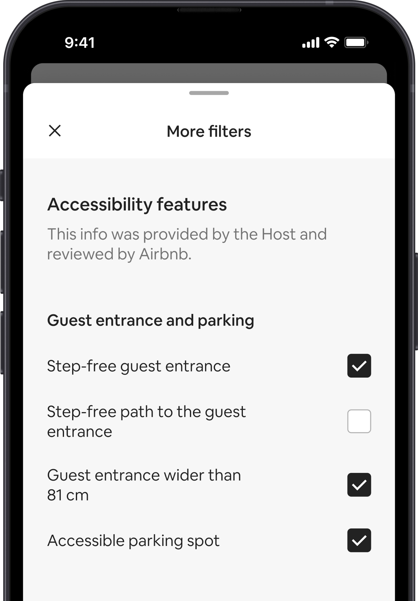 A mobile phone displays the More filters overlay, which is one of many search filters. There is a section heading that reads 'Accessibility Features'. Below that accessibility features are grouped by areas like 'Guest entrance and parking.' There are checkboxes where you can select as many features as you want.