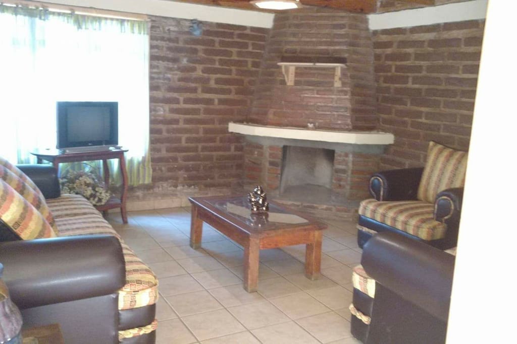 sala de estar con su chimenea y televisión con cable