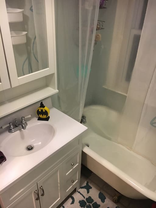Fully updated bathroom with claw foot tub, large vanity and storage for guest toiletries.