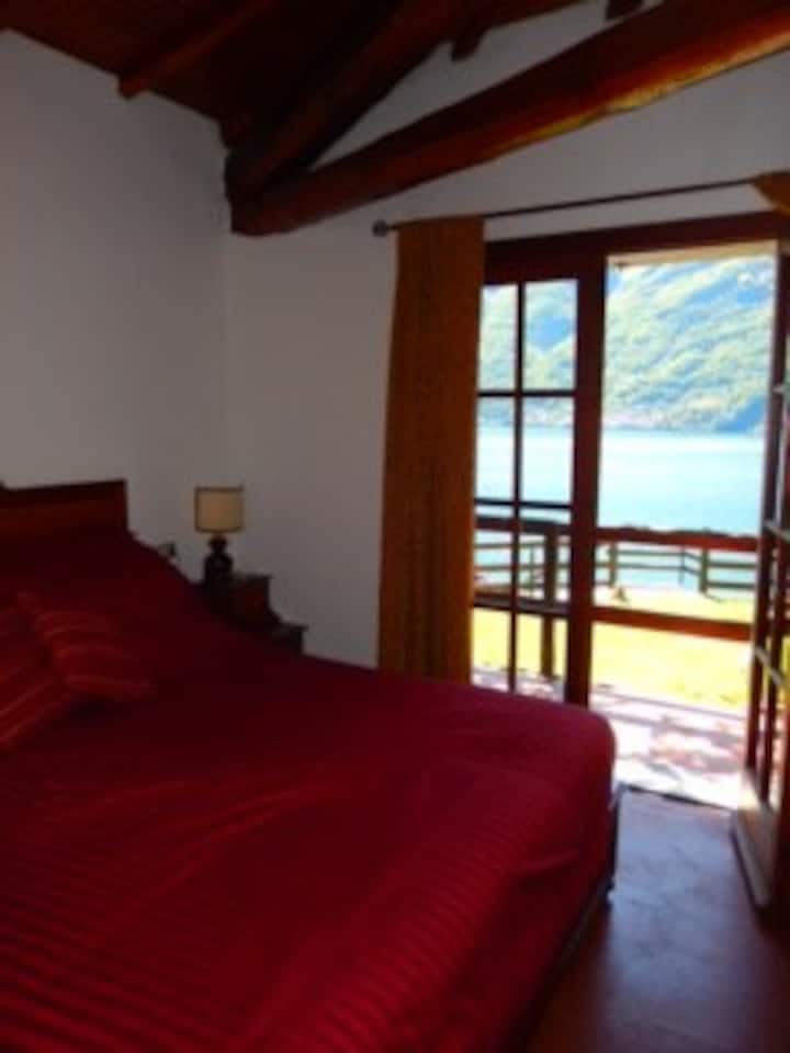 Guest bedroom with king bed and doors opening to Lake.
