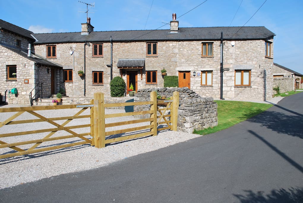 A view of the cottage from the road showing a gated entrance and off road parking