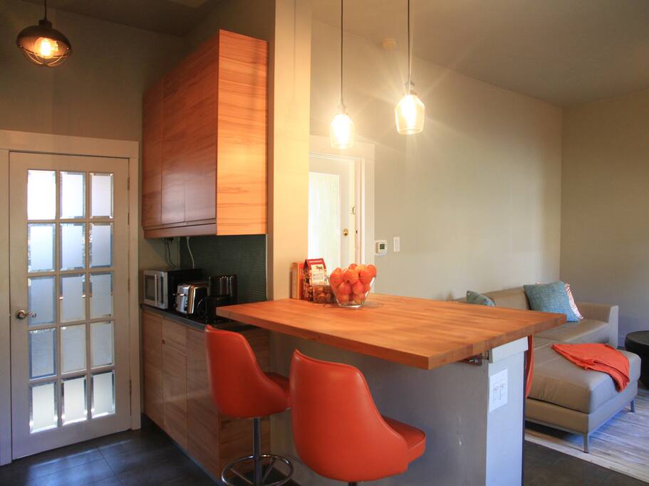 Kitchen with open plan to living room, and door to mudroom that leads out to parking.