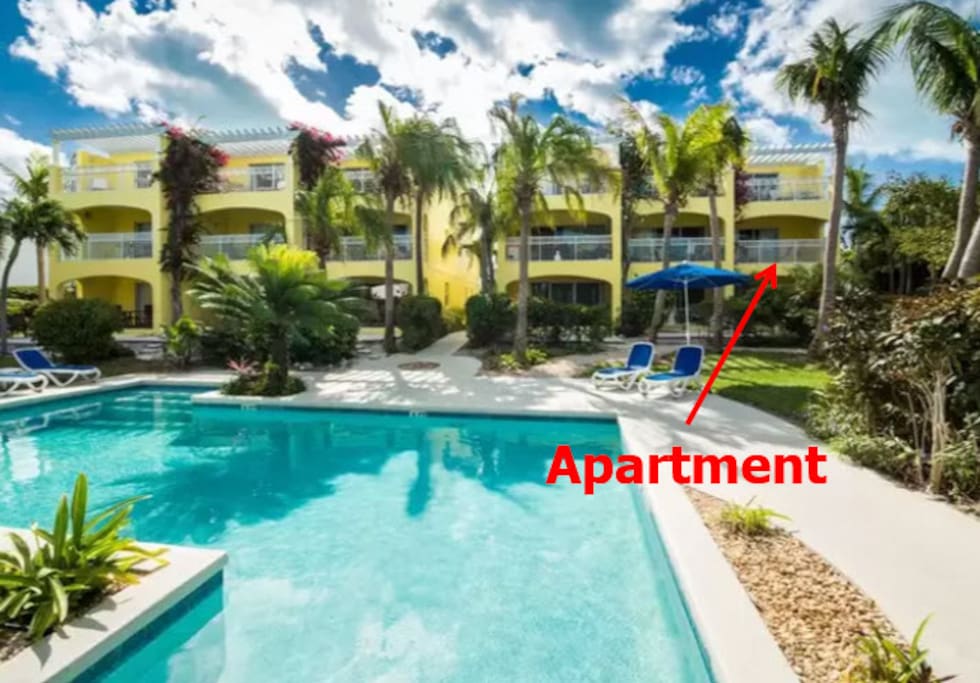 Apartment overlooks pool and garden area.