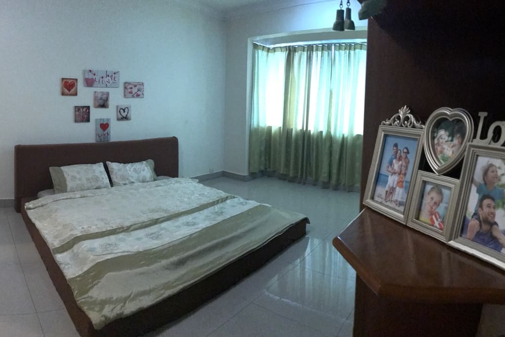 A spacious and comfortable master bedroom with attached bathroom that comes with a long bath and a shower .