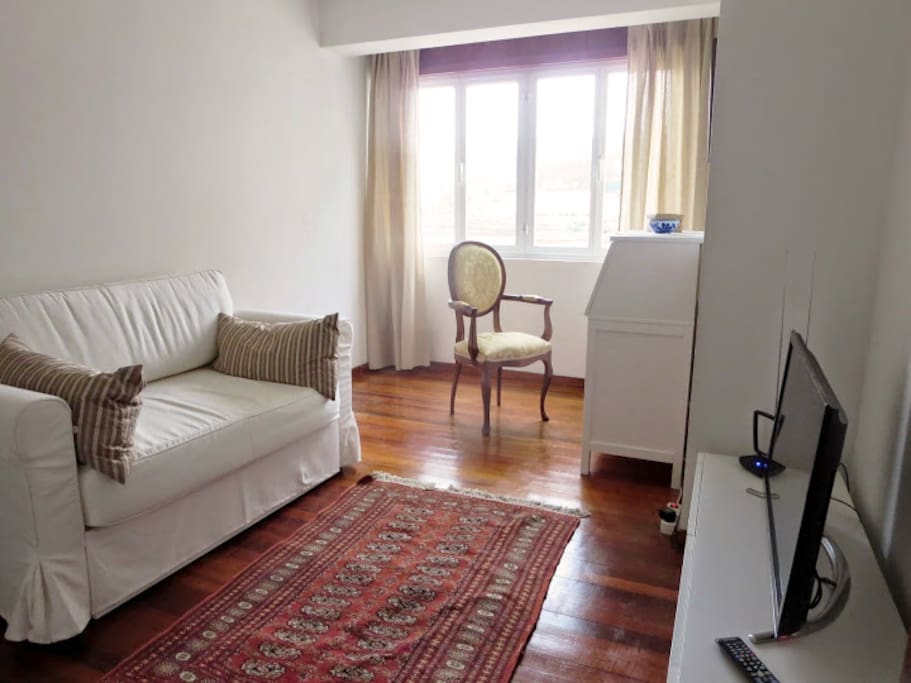 Living room with TV and a Desk perfect for the laptop. This is the place with the sea view.