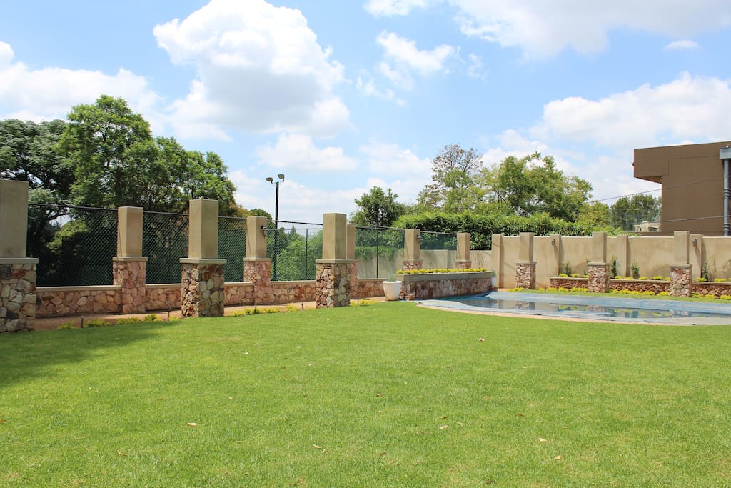 Lush green garden surrounds sparkling swimming pool
