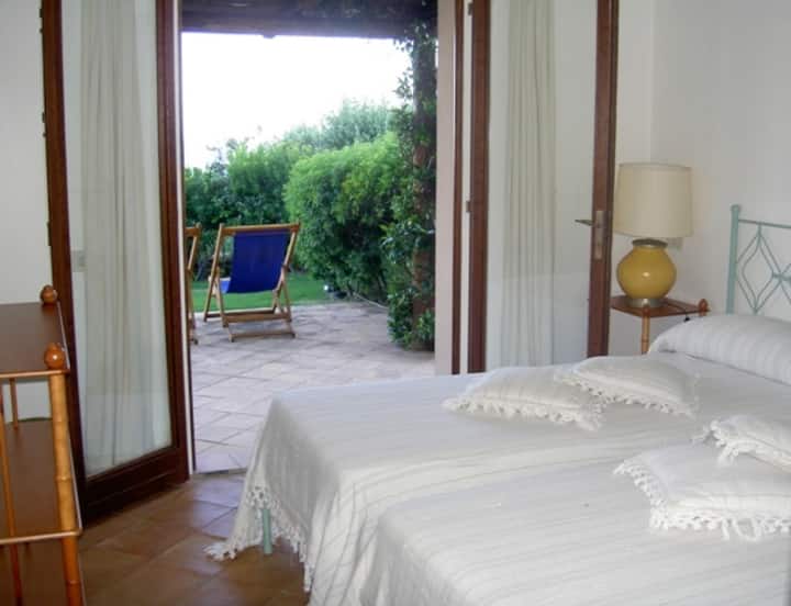 B. Stanza a due letti/ dormitorio con dos camas individuales con ventana a la puerta al jardín 