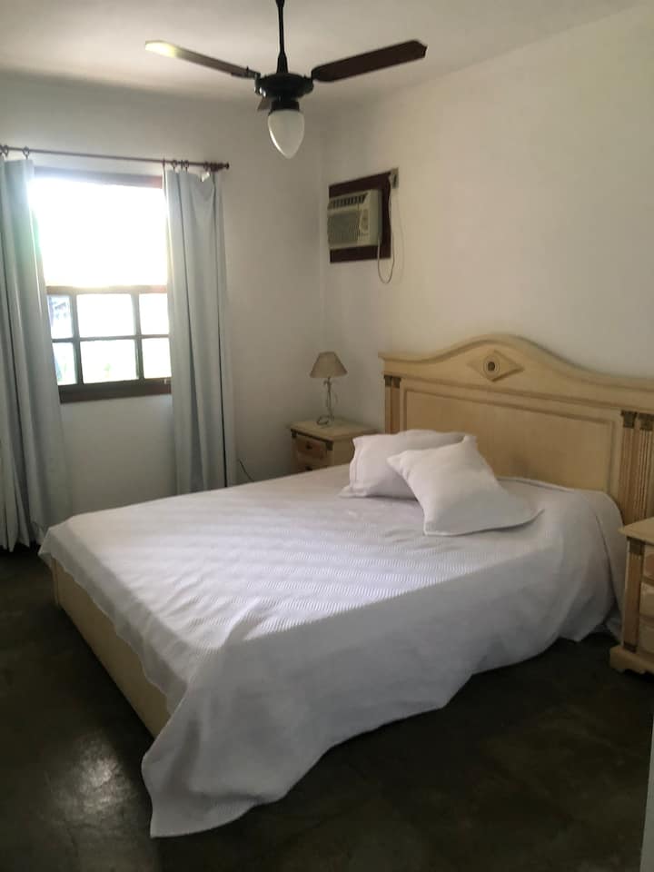 Პირველი სართული ორადგილიანი საძინებელი. Დიდი ზომის საწოლი აუზის ხედით. Კონდიციონერი, ჭერის ვენტილატორი და კარადა.