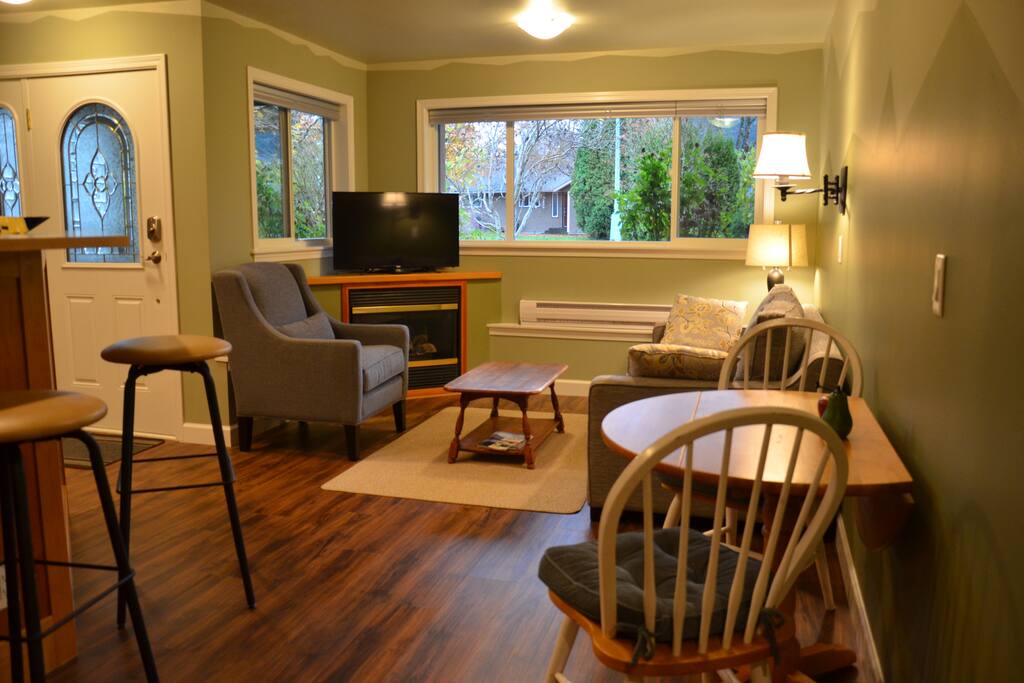 Sitting area with TV and fireplace, views of Tantalus mountain range from the window.