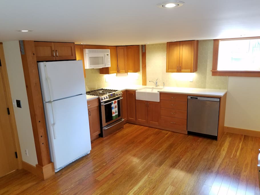 Fully furnished kitchen with brand new gas range, microwave and dishwasher. Custom reclaimed old growth fir cabinets and custom tile backsplash.