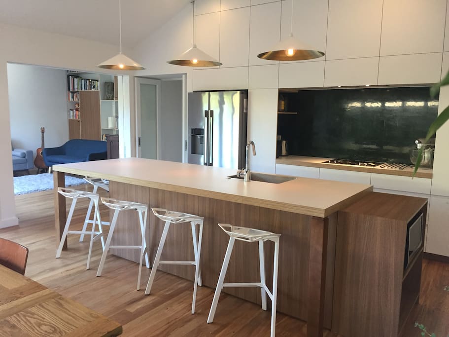 Kitchen. Five stools at the breakfast bar plus long dining table.