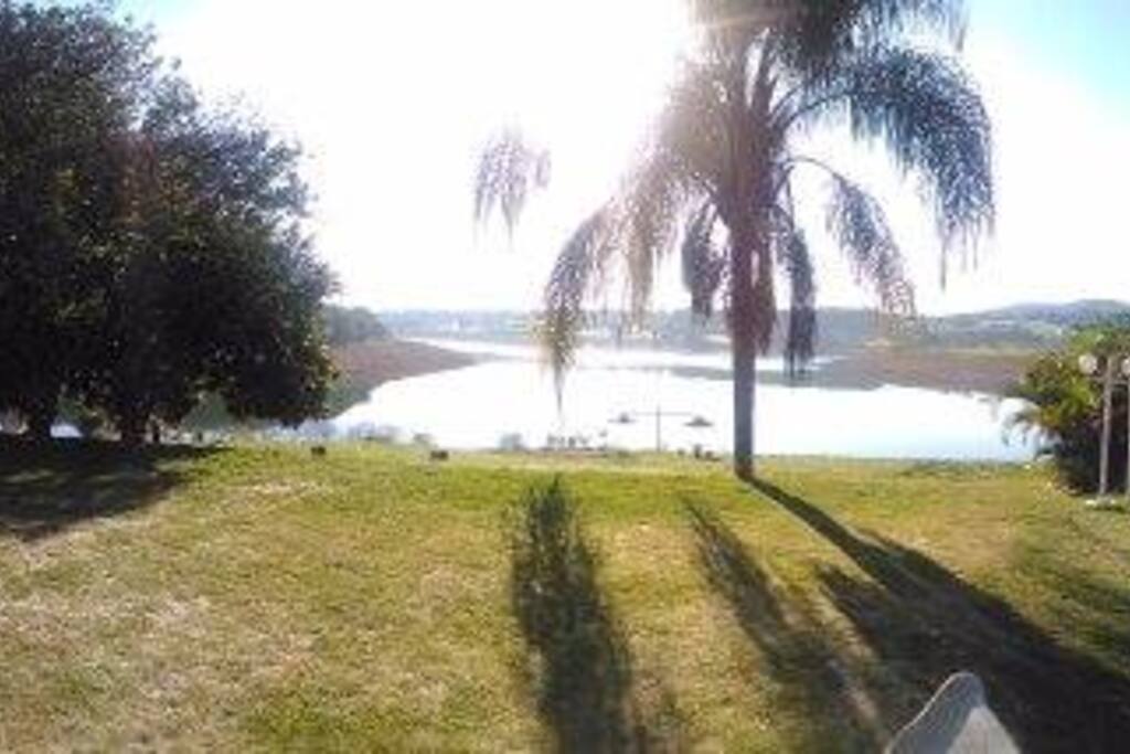 Área de piscina, gramado e churrasqueira todas integradas com a vista para a represa