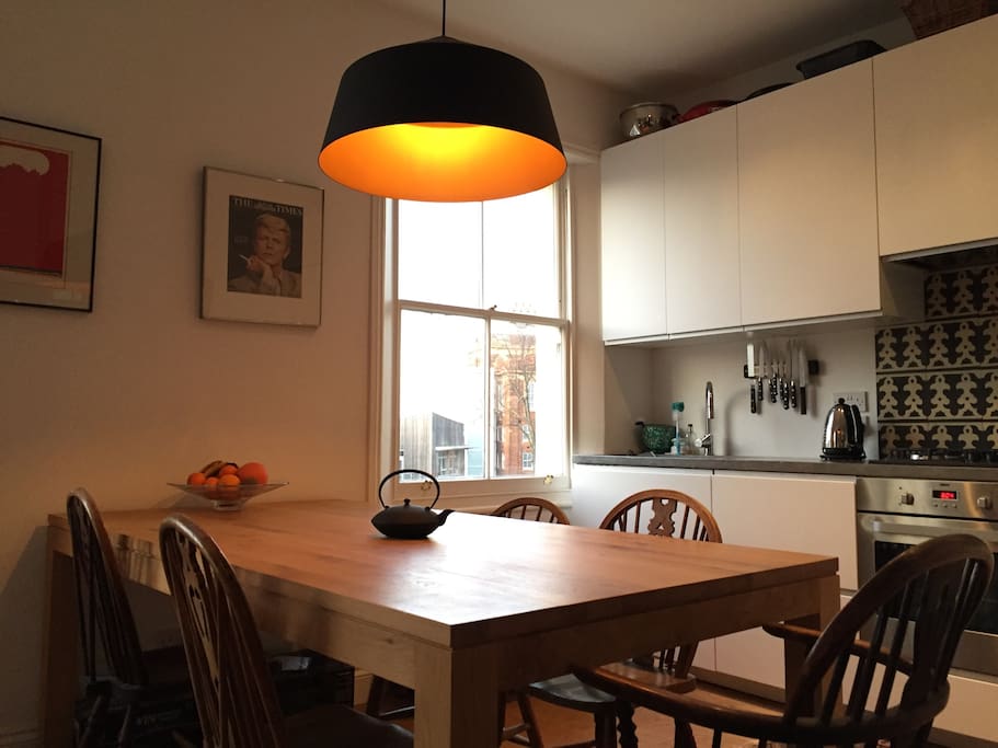 Large dining table and sunlit kitchen
