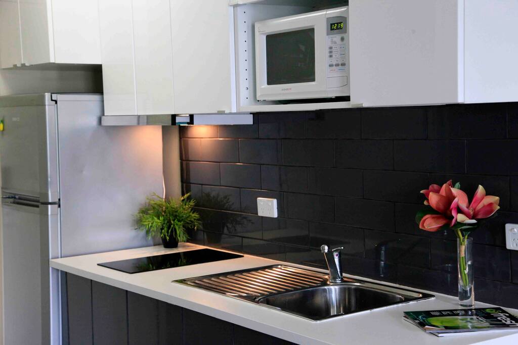 Modern kitchen with big fridge, ceramic cooktop and microwave