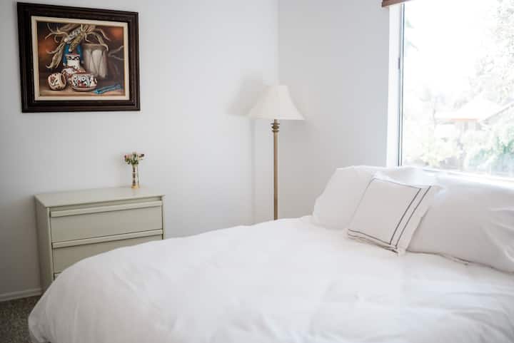 Dormitorio 3 en la planta superior con una cama tamaño queen, persianas opacas y baño privado en suite.