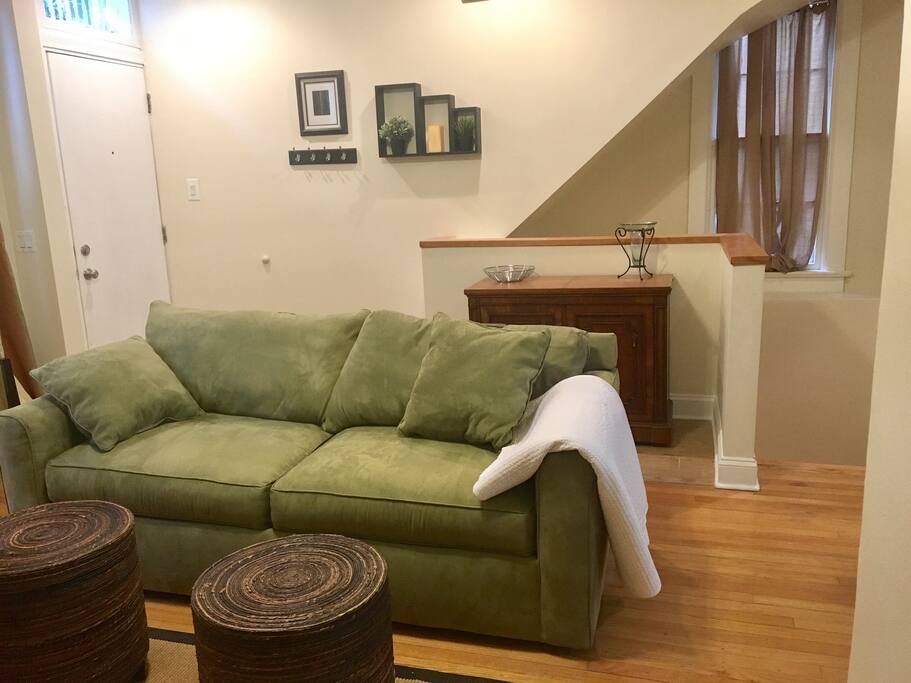 Living room: Pull-out couch, front door on left, stairs to lower level on right (upper level)