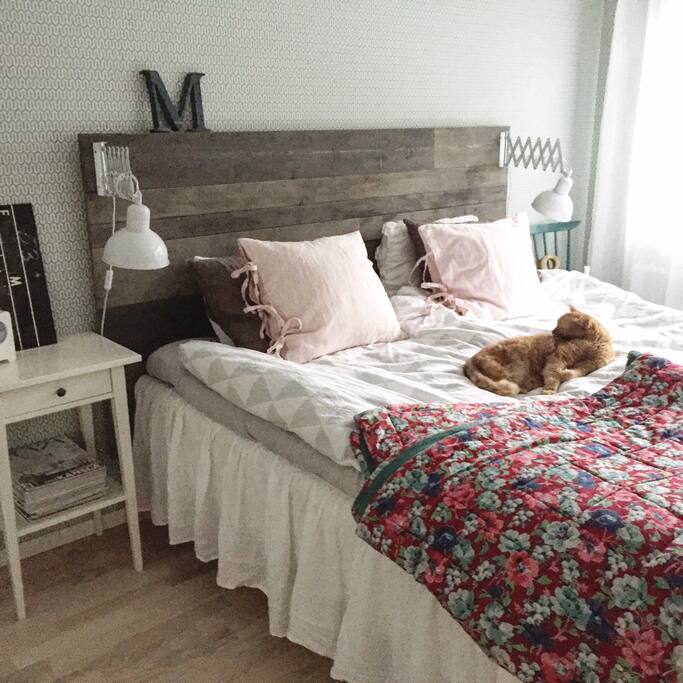 Master bedroom med dubbelsäng och vacker utsikt över skogen.