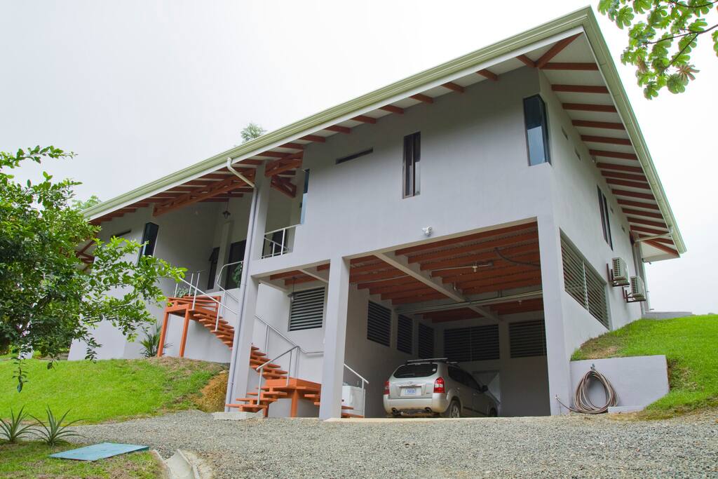Driveway entrance to 2 car parking garage with lower stairwell entry to front door.