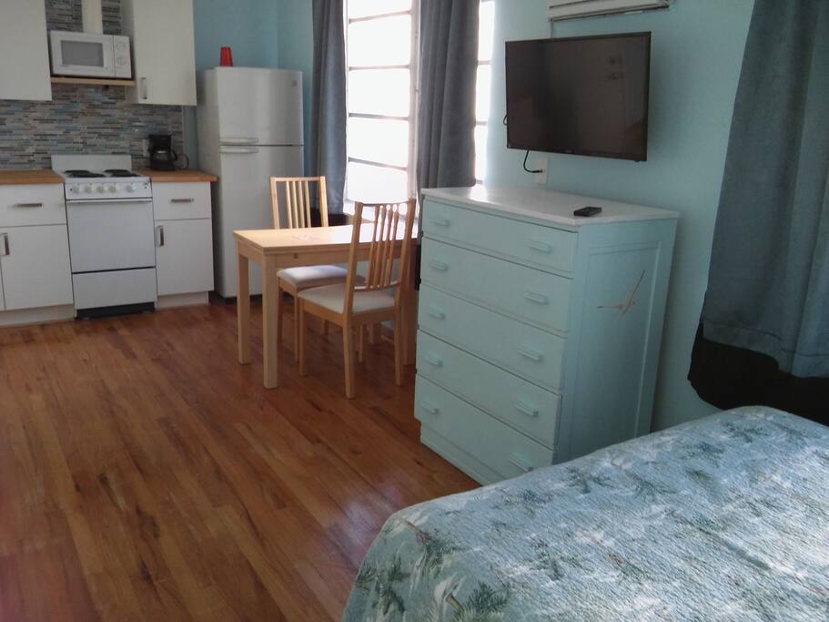 Kitchen and table in distance, dresser and bed in foreground