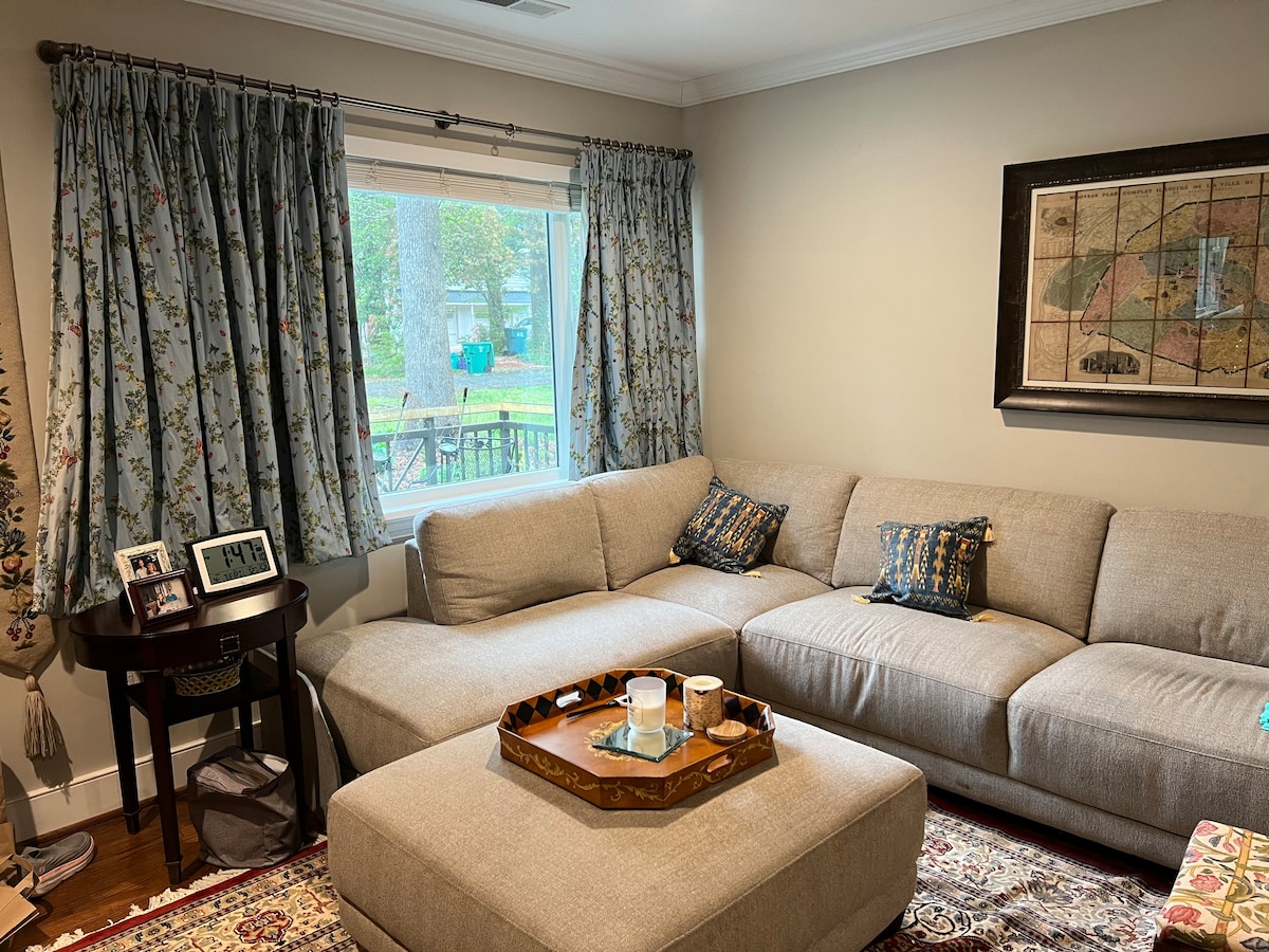 ห้องนั่งเล่นมีโซฟาขนาดใหญ่ที่สะดวกสบายซึ่งหันหน้าไปทางทีวีจอแบนขนาดใหญ่และเตาผิง 