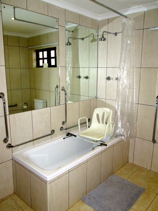 The en suite bathroom is fitted with a bath shower unit and a portable swivel bath chair.