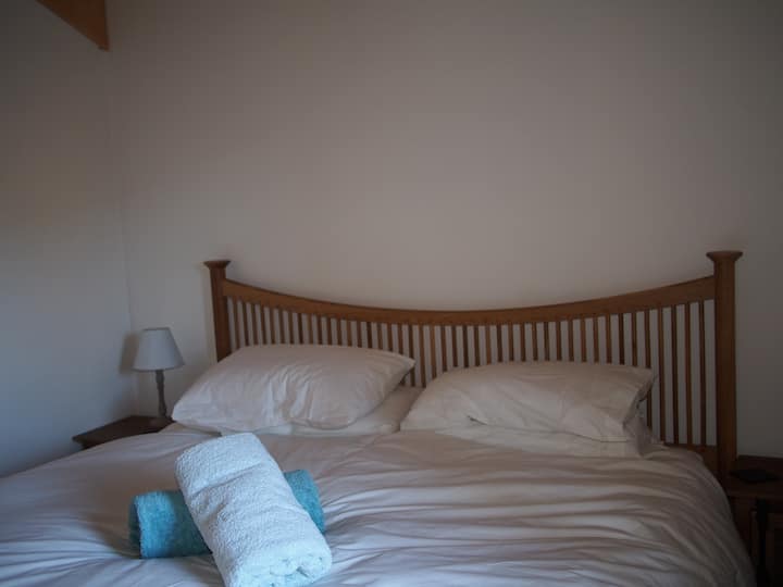 Dormitorio principal en la planta superior con cama tamaño súper king, baño privado y vistas al valle
