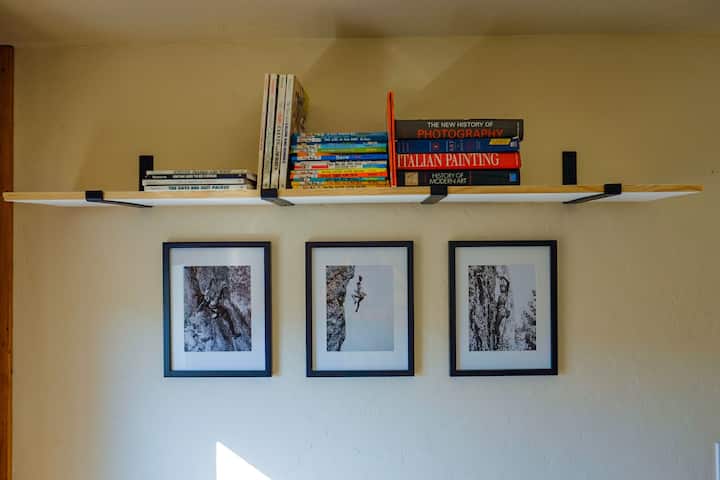 Una pequeña selección de libros en el dormitorio con dos camas individuales.