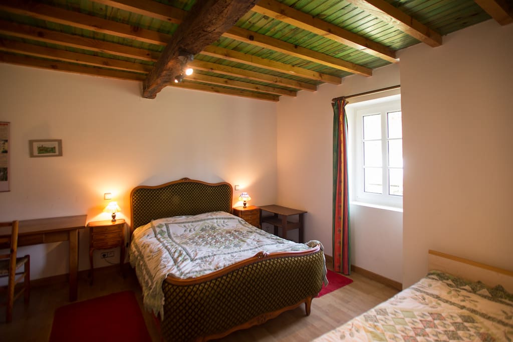 Une chambre avec 1 lit deux personne et 1 lit une personne, placard de rangement, accès privé à la SDB.